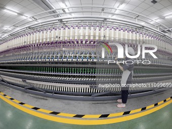 A worker is operating an intelligent production line at a textile company in Taizhou, Jiangsu Province, China, on March 26, 2024. (