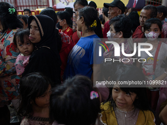 People are waiting to receive food for iftar during the holy month of Ramadan at a temple in Jakarta, Indonesia, on March 26, 2024. As milli...