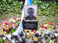 A picture of Alexei Navalny and democratic Russian flag are seen next to flowers and candles in a tribute to Navalny in front of the Russian...