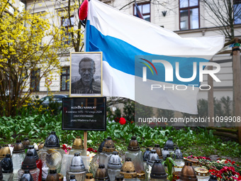 A picture of  Alexei Navalny and democratic Russian flag are seen next to flowers and candles in a tribute to Navalny in front of the Russia...