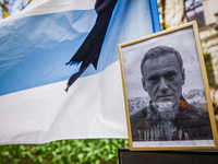 A picture of  Alexei Navalny and democratic Russian flag are seen next to flowers and candles in a tribute to Navalny in front of the Russia...