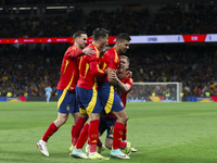 Several players from Spain are celebrating a goal during the friendly match between Spain and Brazil at Santiago Bernabeu Stadium in Madrid,...