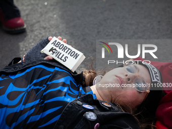 An anti-abortion activist lies 'dead' on the ground during a demonstration at the Supreme Court as it hears oral arguments in a case that co...