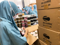 Employees are putting cookies into jars at the J&C Cookies factory in Bandung, Indonesia, on March 27, 2024. The cookie manufacturer, J&C Co...