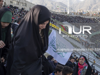 A veiled Iranian woman is carrying a religious flag as she arrives at the Azadi (Freedom) Stadium to participate in a religious gathering co...