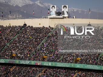 A huge crowd is sitting under portraits of Iran's Supreme Leader Ayatollah Ali Khamenei (R), and the late Leader Ayatollah Ruhollah Khomeini...