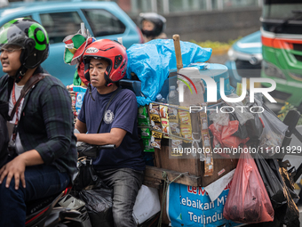 An Indonesian Starbikes vendor is carrying a motorcycle-mounted instant coffee maker in the business district during the holy month of Ramad...