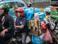 An Indonesian Starbikes vendor is carrying a motorcycle-mounted instant coffee maker in the business district during the holy month of Ramad...