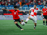 Marwan Attia is playing with a Croatian national team player during a friendly football match between Egypt and Croatia at Misr Stadium in t...