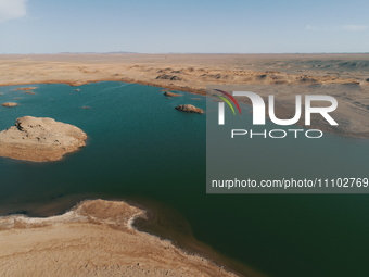 A view of the arid Yadan landscape with a moist lake nestled in the depths of the Gobi desert in Hami, Xinjiang province, China, on March 24...