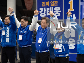 Lee Jae-myung, the leader of the Democratic Party of Korea, is raising his hand in greeting from the podium during the Democratic Party of K...