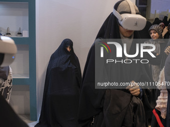A veiled Iranian woman is wearing a Virtual Reality headset to watch a simulation of Imam Hussein and the battle of Karbala at the Meta-Mosq...