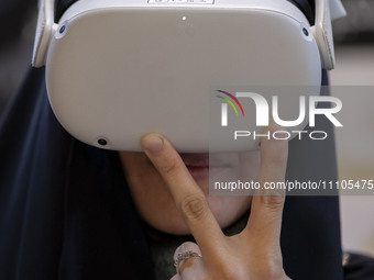 A veiled Iranian woman is wearing a Virtual Reality headset to watch a simulation of Imam Hussein and the battle of Karbala at the Meta-Mosq...