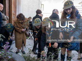 People taking olive branches from the ground are seen in L’Aquila, Italy, on March 24th, 2024. Palm Sunday, observed on the Sunday before Ea...
