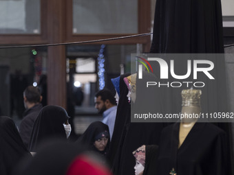 A veiled Iranian woman is looking at mannequins covered with black chadors during the Hijab and Chastity fair at the Imam Khomeini Grand Mos...