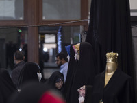 A veiled Iranian woman is looking at mannequins covered with black chadors during the Hijab and Chastity fair at the Imam Khomeini Grand Mos...