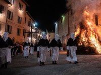People wearing black and white hooded costumes are seen next to a giant fire during Good Friday procession in Gubbio, Italy, on March 29th,...