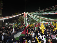 Iranian protesters are waving Palestinian flags as they gather to condemn the Israeli airstrike against the Iranian consulate in Syria, at P...