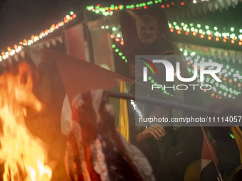 Iranian protesters are burning the U.S. flag and one of them is holding up a portrait of the former commander of the Islamic Revolutionary G...