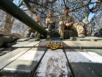Three servicemen are sitting on a tank of the 1st Tank Brigade of the Ukrainian Ground Forces in Ukraine, on March 31, 2024. NO USE RUSSIA....