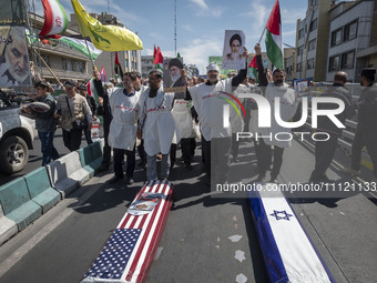 A group of Iranian protesters is wearing shrouds and carrying portraits of Iran's Supreme Leader Ayatollah Ali Khamenei and the late Leader...