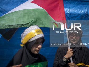 A woman is holding a Palestinian flag during a rally commemorating International Quds Day, also known as Jerusalem Day, and a funeral for me...