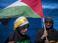 A woman is holding a Palestinian flag during a rally commemorating International Quds Day, also known as Jerusalem Day, and a funeral for me...