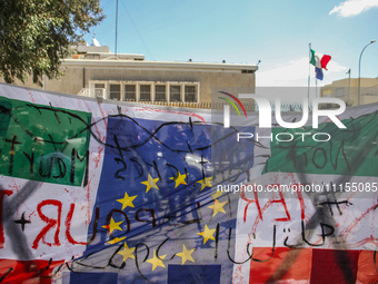 A large banner featuring the 12 gold stars of the European flag is being displayed in front of the Italian Embassy in Tunis, Tunisia, on Apr...