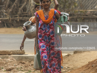 Women on their way home with water filled pitchers collected from a municipal water tank on World Water Day in Gauhati in the northeastern s...