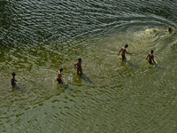 Indian youth take bath in Ganges River to cool off ,during a hot day in Allahabad on March 26.2016. (