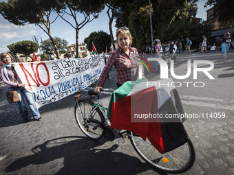 Rome, Italy – May 17, 2014: A woman with a bike holds a Palestinian flag during a nationwide demonstration against the privatization of the...