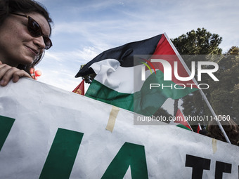 Rome, Italy – May 17, 2014: Protester holds a Palestinian flag during a nationwide demonstration against the privatization of the commons an...
