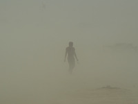 An indian commuter walks on, in a dust storm,during a hot day, in Allahabad on April 7,2016. (