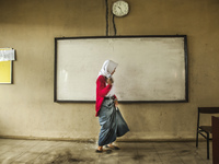A student walking in flooded classroom in high school SMKN 1, Village Kramat Sari, Pekalongan, Central Java, Indonesia, on April 11, 2016. T...