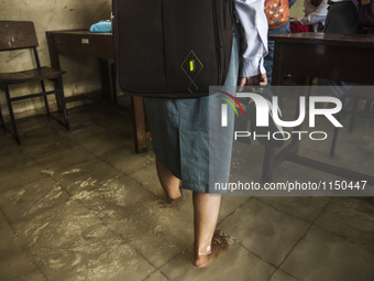 A student walking in flooded class in high school SMKN 1, Village Kramat Sari, Pekalongan, Central Java, Indonesia, on April 11, 2016. The f...