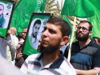 Supporters of the Palestinian militant group Hamas chant slogans to support Palestinian prisoners on hunger strike at Israeli jails, while h...