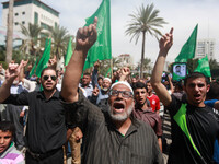 Supporters of the Palestinian militant group Hamas chant slogans to support Palestinian prisoners on hunger strike at Israeli jails, while h...