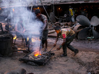 Worker throwing metal peices in to the furnace to be melted. Ship building industry in Bangladesh spreading rapidly where workers from all a...
