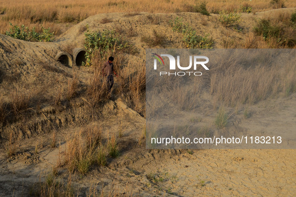 An indian youth crosses a dried water canal, in shringerpur village, 17 kms from Allahabad, during a hot day on April 29,2016. 