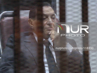 Egypt's deposed president Hosni Mubarak waves from behind the accused cage during his trial on May 21, 2014 in Cairo. An Egyptian court sent...