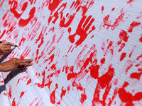 Palestinians lay hands imprint as they tape part a protest in Gaza City on May 22, 2014 to express solidarity with Palestinian prisoners on...