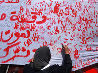 Palestinians lay hands imprint as they tape part a protest in Gaza City on May 22, 2014 to express solidarity with Palestinian prisoners on...