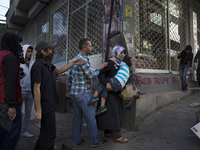A woman carried her child past protesters who took to the streets in the Alevi enclave of Okmeydani in Istanbul on May 22, 2014 after Ugur K...