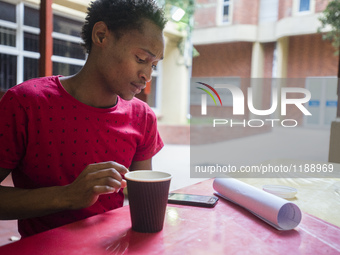 A student of the University of Namibia during his break with a cup of coffee, Windhoek, Namibia ( (