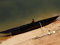 A fisherman paints his fishing country boat on the banks of Kuakhai River outskirts of the eastern Indian city Bhubaneswar, India, Monday, 0...