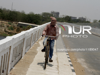 Man on a bicycle covered by the heat for cool themselve and beat the heat in today’s hot afternoon outskirts of the eastern Indian city Bhub...
