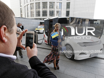 People take pictures in front the prototype of a new Ukrainian electric car 
