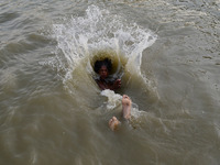An indian boy dives in Yamuna river to cool off during a hot day in Allahabad on May 21,2016. (