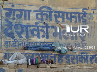 Indian people take rest in the shades of a wall of Allahabad Fort,during a hot day in Allahabad on May 21,2016. (