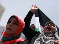 Palestinians wave their national flags during a rally to demand the end of Palestinian political divisions, at the main square of Gaza City....